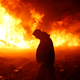 Chanse Zavalla, 26, from California, walks past a building set alight by protesters. (Reuters/Terray Sylvester)